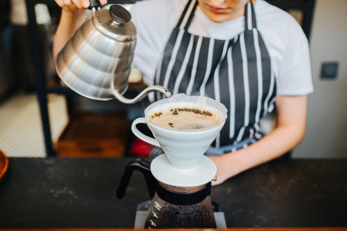 باریستا در حال دم کردن قهوه به روش پور اور با کمکس و کتری دهانه باریک