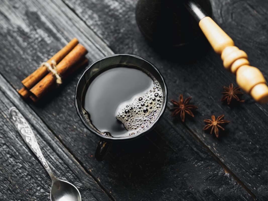 فنجان قهوه سیاه تازه دم شده با مواد افزودنی سالم: دارچین، کاکائو و روغن MCT